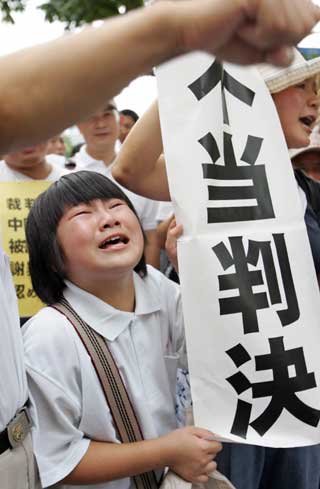 A Chinese girl cries as she holds a banner with the words "Unjust Ruling", after a legal judgement, in front of the Tokyo High Court July 19, 2005. A Tokyo court on Tuesday rejected demands from Chinese plaintiffs for compensation and an apology from Japan's government for biological warfare conducted in China before and during World War Two.