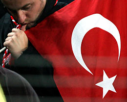 Turkish soccer fan reacts while holding his national flag after Swiss Marco Streller scored the second goal that ended Turkey's World Cup dream during their World Cup 2006 European zone, second leg play-off qualifying soccer match at the Sukru Saracoglu stadium in Istanbul November 16, 2005.