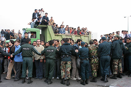 olice form a cordon as bystanders and anxious relatives gather near the site of a plane crash in Tehran December 6, 2005.