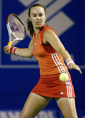 Former world number one Martina Hingis of Switzerland returns the ball to retired Russian tennis star Anna Kournikova during an exhibition match on the Copacabana beach in Rio de Janeiro December 10, 2005. Kournikova withdrew in the second set after suffering a right hand injury.