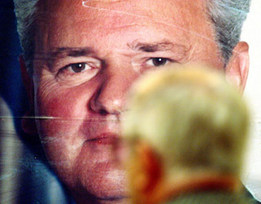 A supporter of Slobodan Milosevic looks at a giant poster of the late Yugoslav leader in the headquarters of pro-Milosevic support group "Freedom" in Belgrade March 11, 2006.