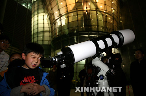 10月24日，一名兒童在北京天文館用天文望遠鏡觀賞月亮。 當日，搭載著我國首顆探月衛星嫦娥一號的長征三號甲運載火箭在西昌衛星發射中心三號塔架點火發射。連日來，北京天文館免費開放天文館和觀測儀器，吸引眾多市民前來觀月。 新華社記者李明放攝 
