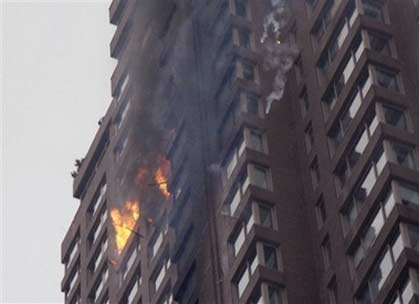 Debris falls from an apartment building on New York's Upper East Side after a small plane with New York Yankees pitcher Cory Lidle aboard crashed into it Wednesday, Oct. 11, 2006. (AP